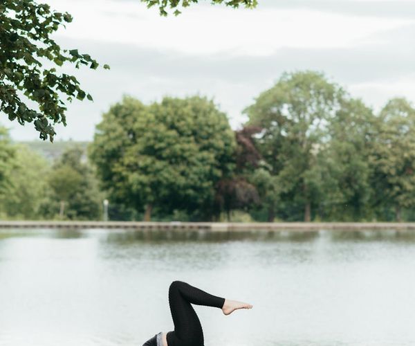 Child balancing on one leg in a tree yoga pose.